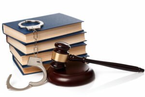 Gavel, books and handcuffs on white background